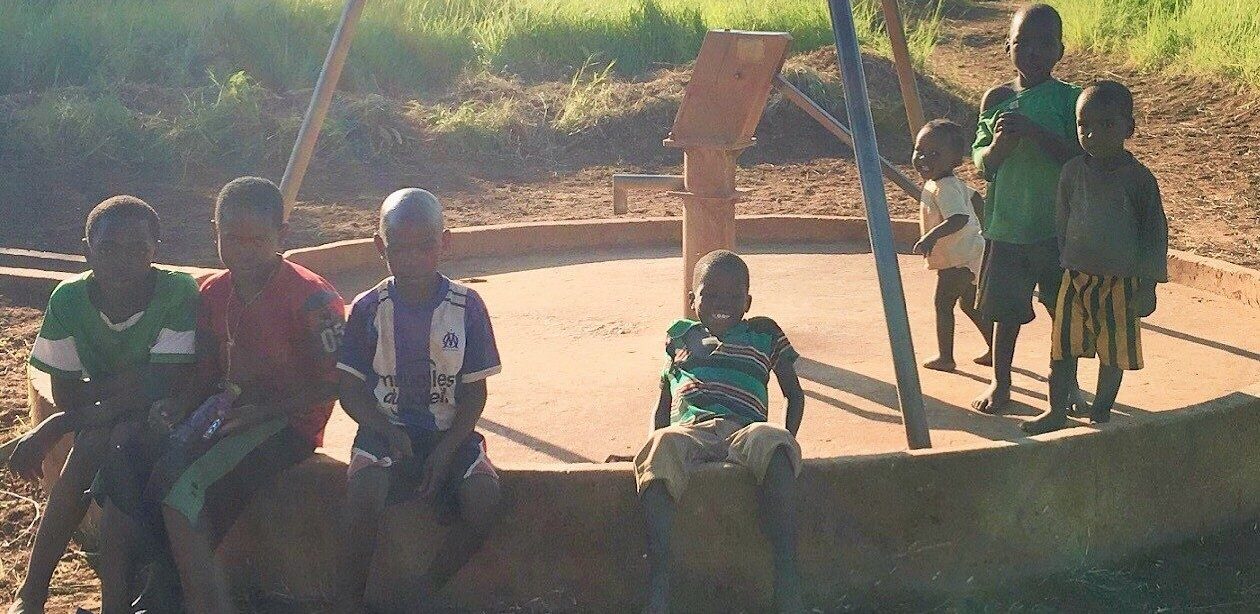 Children beside a community handpump in Zambia