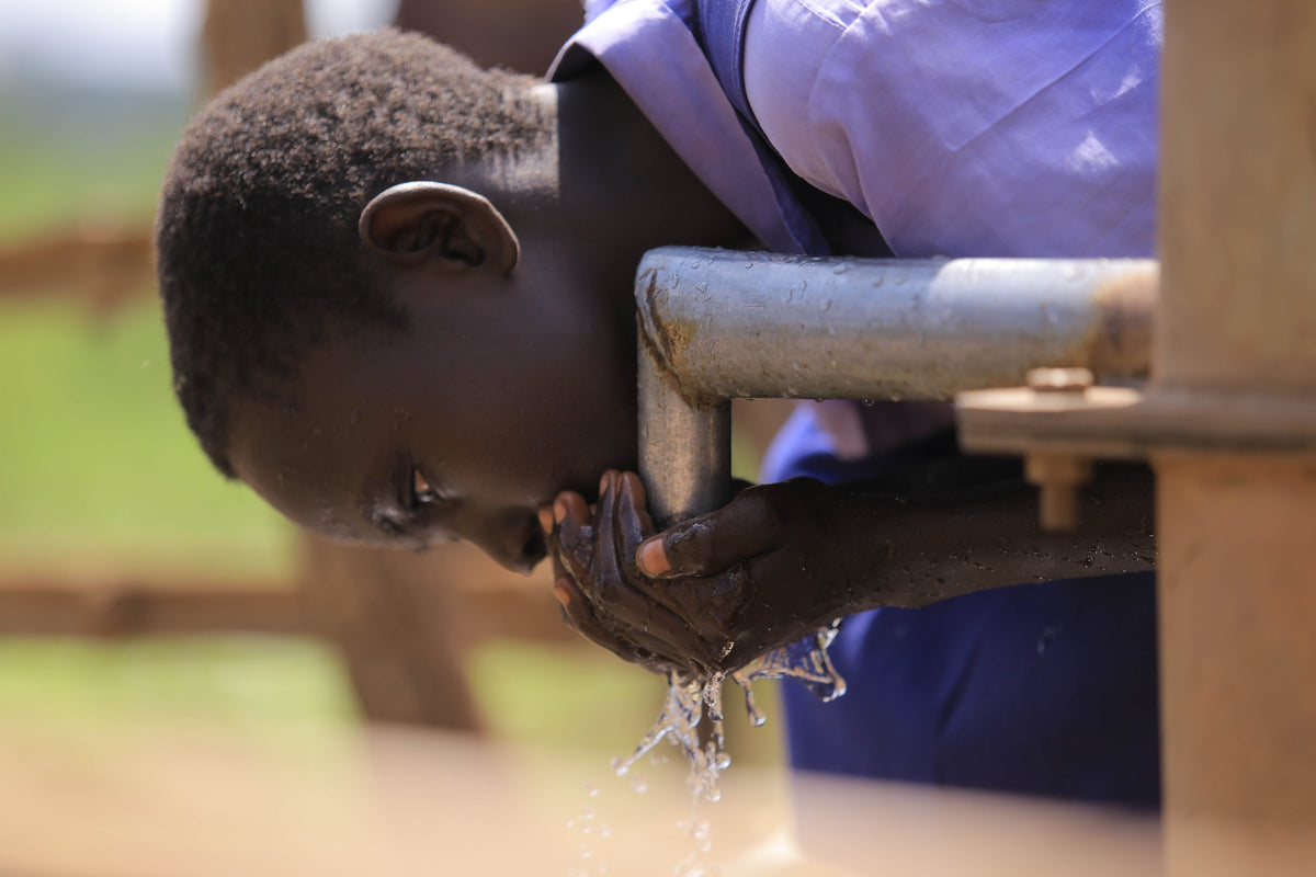 A community member drinking water at a CO2balance safe water project in Uganda