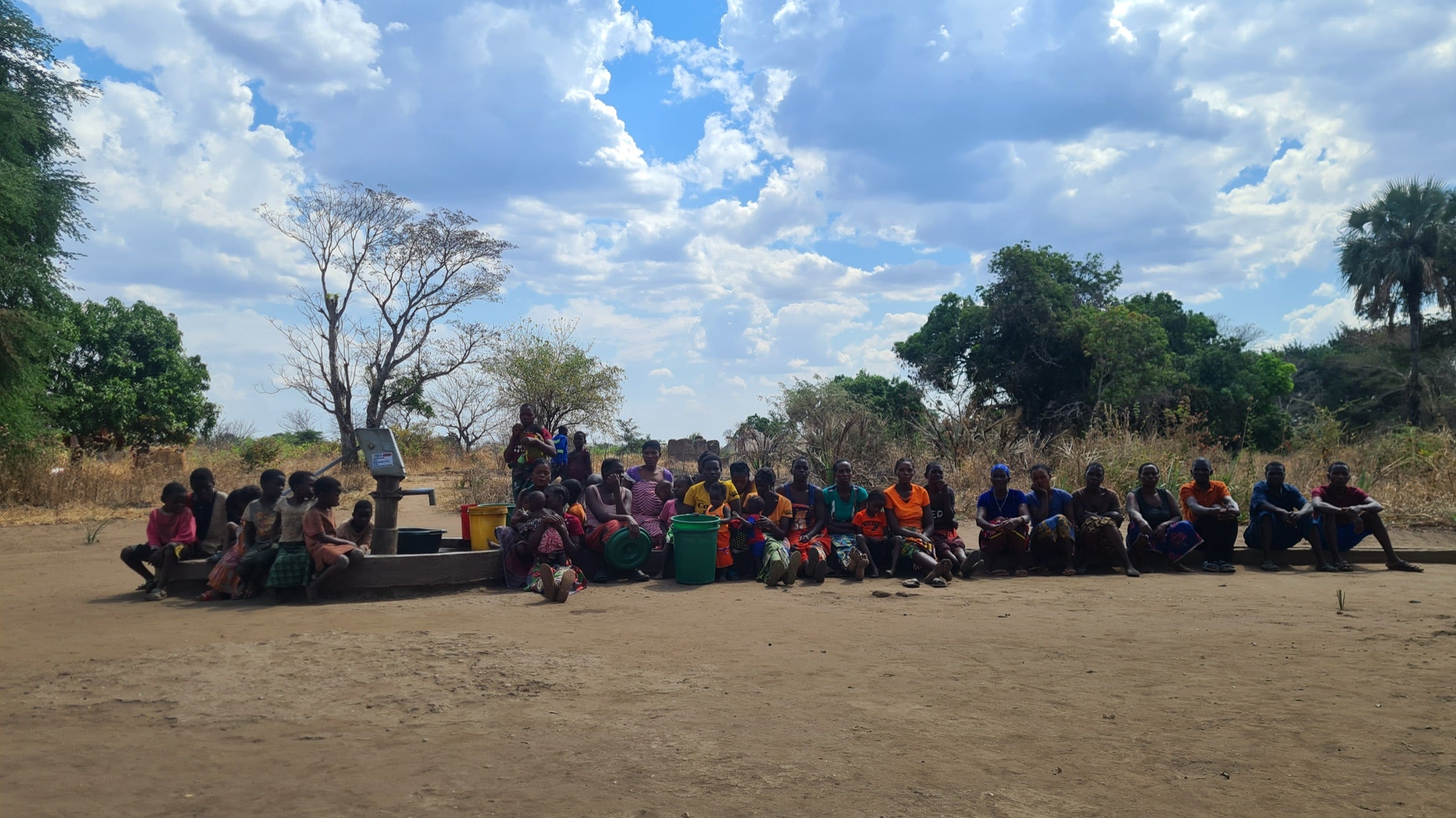 Community members gathered around a safe water project in Uganda