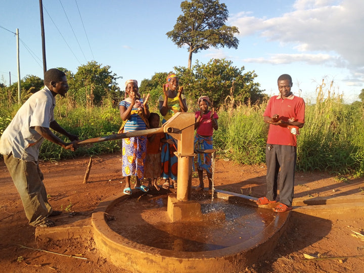 Community members gathered around a working handpump in Mozambique